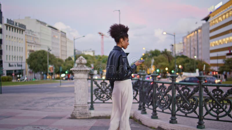 Femme romantique en attente d'une réunion sur la place de la ville. jeune fille africaine banque de vidéos