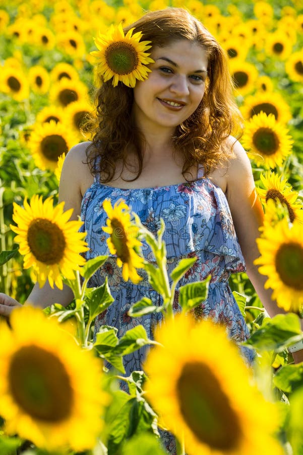 Femme rousse joyeuse avec le tournesol dans les cheveux photos stock