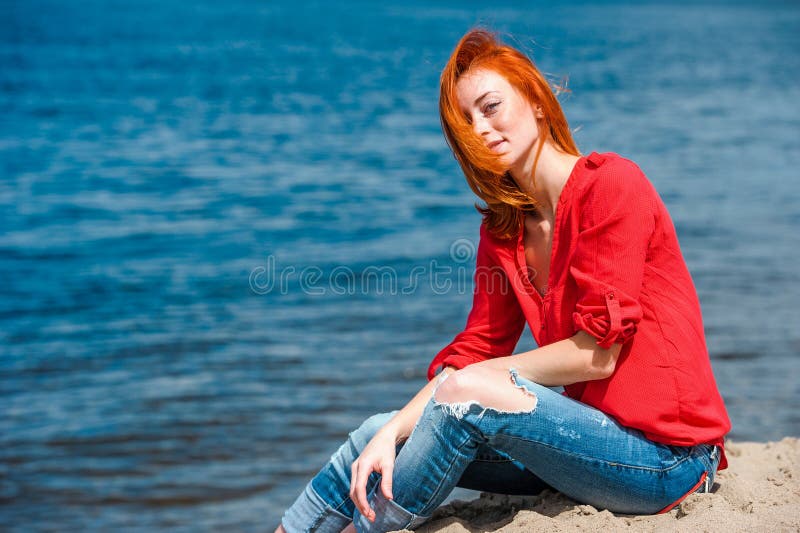 Femme rousse joyeuse s'asseyant confortablement et souriant photos libres de droits