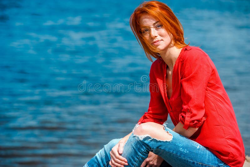 Femme rousse joyeuse s'asseyant confortablement et souriant photos libres de droits