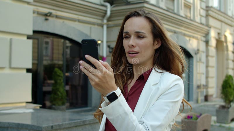 Femme réussie d'affaires ayant la vidéoconférence par téléphone dehors banque de vidéos