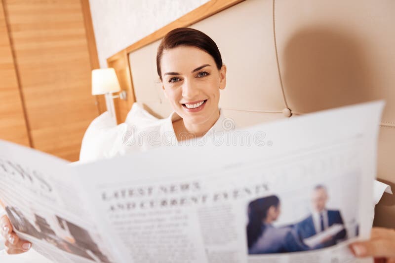 Femme réussie gaie contrôlant le journal photographie stock libre de droits Femme réussie gaie contrôlant le journal photographie stock libre de droits