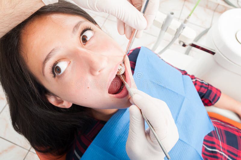 Femme s'asseyant dans la chaise de dentiste vérifié par le docteur photographie stock Femme s'asseyant dans la chaise de dentiste vérifié par le docteur photographie stock
