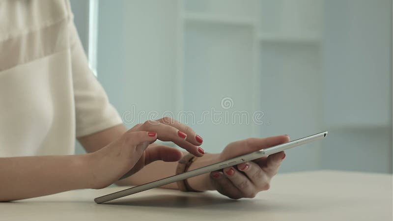Femme s'asseyant dans la table de bureau et la tablette tactile