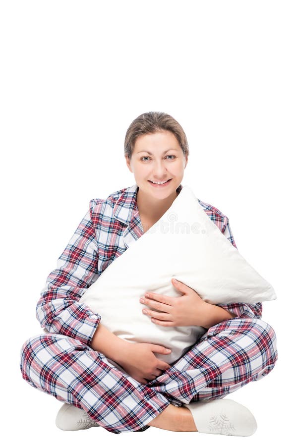 Femme s'asseyant sur le plancher étreignant l'oreiller mol contre le blanc images stock Femme s'asseyant sur le plancher étreignant l'oreiller mol contre le blanc images stock