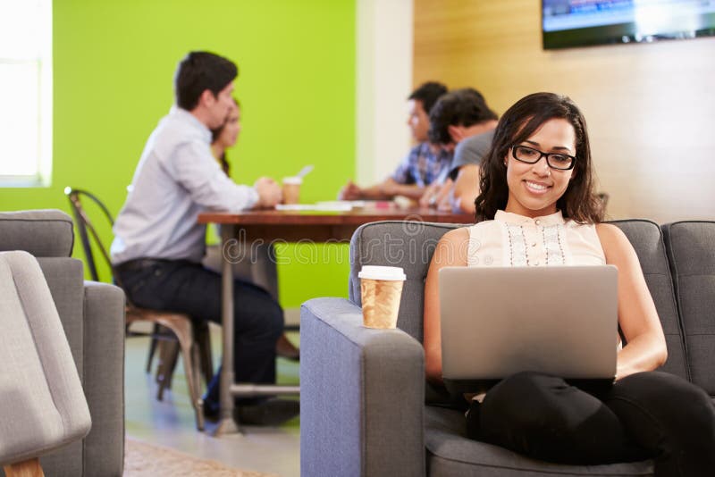 Woman Sitting On Sofa And Working In Design Studio. Woman Sitting On Sofa And Working In Design Studio