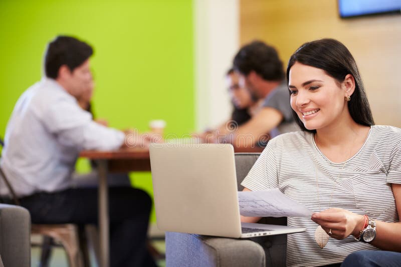 Woman Sitting On Sofa And Working In Design Studio. Woman Sitting On Sofa And Working In Design Studio