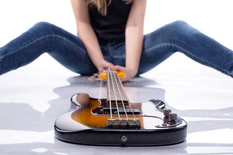 Femme s'asseyante avec la guitare basse photo libre de droits Femme s'asseyante avec la guitare basse photo libre de droits