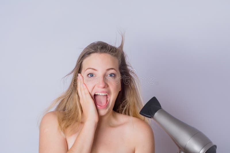 Femme s?chant ses cheveux avec le dessiccateur images libres de droits Femme s?chant ses cheveux avec le dessiccateur images libres de droits