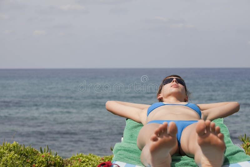 Femme s'exposant au soleil sur le cabriolet image libre de droits Femme s'exposant au soleil sur le cabriolet image libre de droits