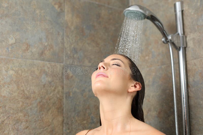 Femme satisfaisante ayant la douche sur une salle de bains