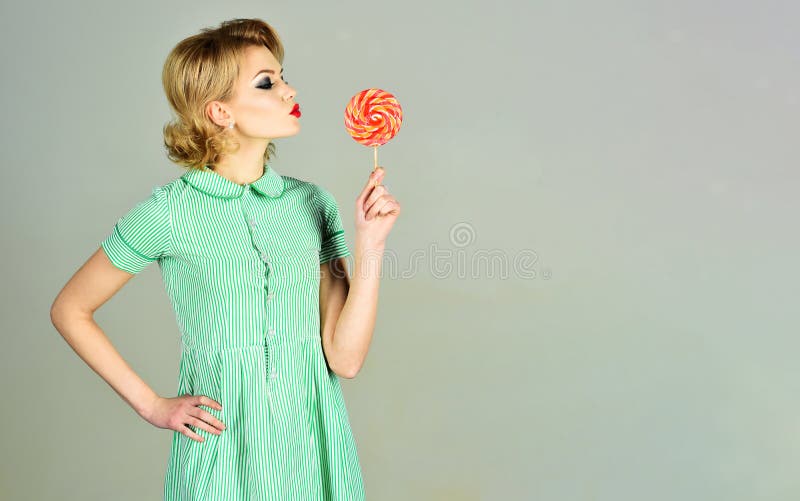 Femme sexy avec la coiffure mode tient la lollipop colorée. Aliments sucrés. Pinup fille avec maquillage brillant tenir bonbon lol photo stock