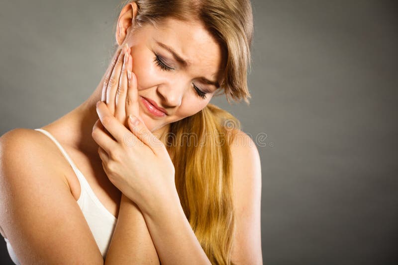 Dental care and toothache. Young woman achy girl suffering from terrible tooth pain, touching pressing her cheek by hand palm. Dental care and toothache. Young woman achy girl suffering from terrible tooth pain, touching pressing her cheek by hand palm.