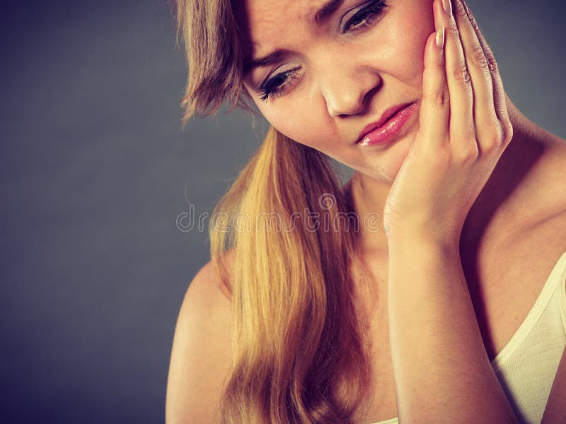 Dental care and toothache. Young woman achy girl suffering from terrible tooth pain, touching pressing her cheek by hand palm. Dental care and toothache. Young woman achy girl suffering from terrible tooth pain, touching pressing her cheek by hand palm.