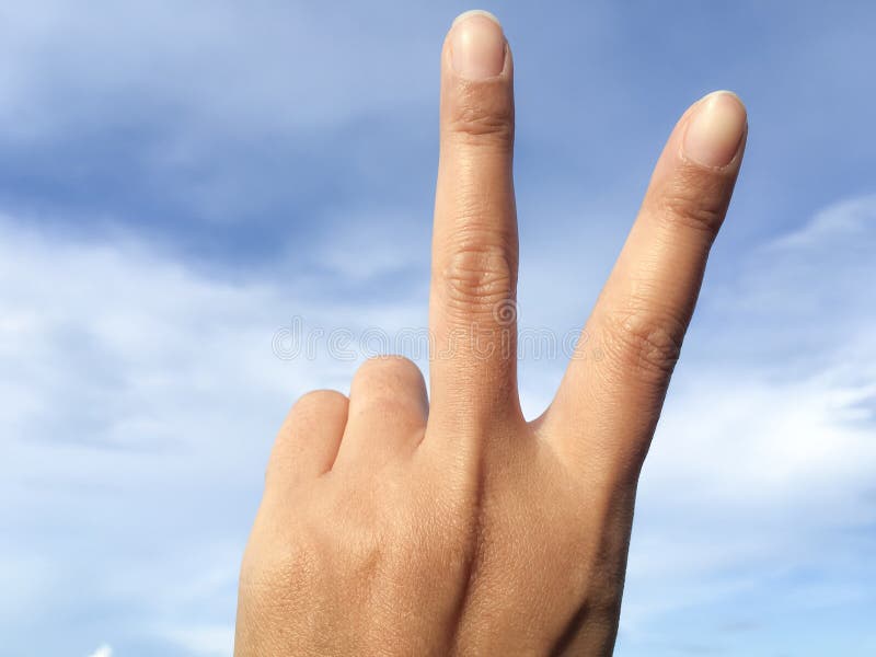 Femme soulevant deux doigts en main c'est symbole de combat ou de victoire de force de paix d'expositions, signe de paix, numéro