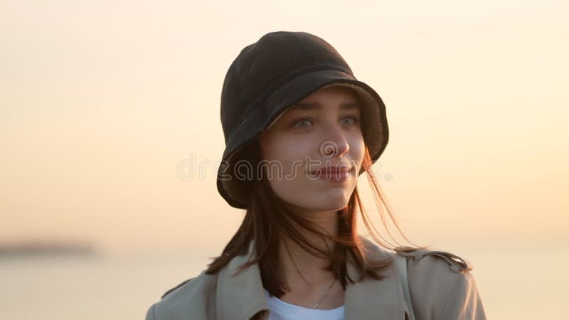 Femme souriant et posant tout en se tenant sur la plage pittoresque de mer pour égaliser le coucher du soleil. clips vidéos