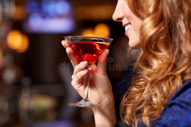 Femme souriante buvant un cocktail à la discothèque images libres de droits