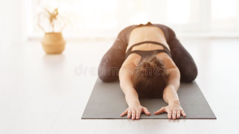 Femme sportive faisant l'exercice d'enfant, pose de Balasana photos stock Femme sportive faisant l'exercice d'enfant, pose de Balasana photos stock
