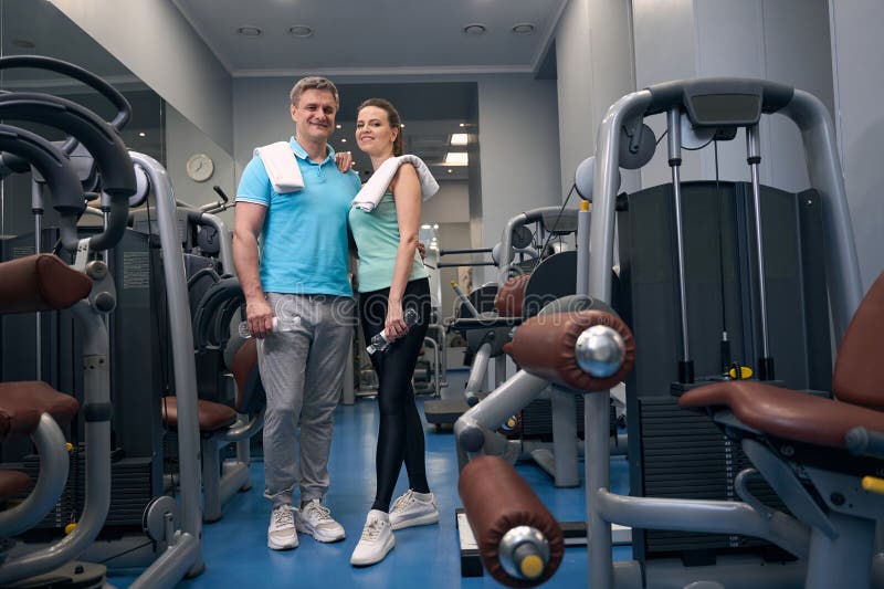 Femme sportive souriante et partenaire de fitness heureux dans le club de fitness images libres de droits