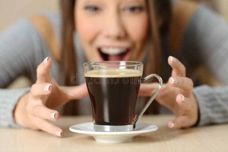 Femme stupéfaite regardant une tasse de café image libre de droits Femme stupéfaite regardant une tasse de café image libre de droits