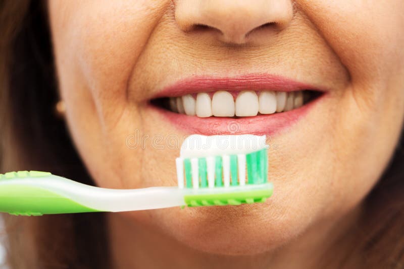 Femme sup?rieure avec la brosse ? dents se brossant les dents photos libres de droits Femme sup?rieure avec la brosse ? dents se brossant les dents photos libres de droits