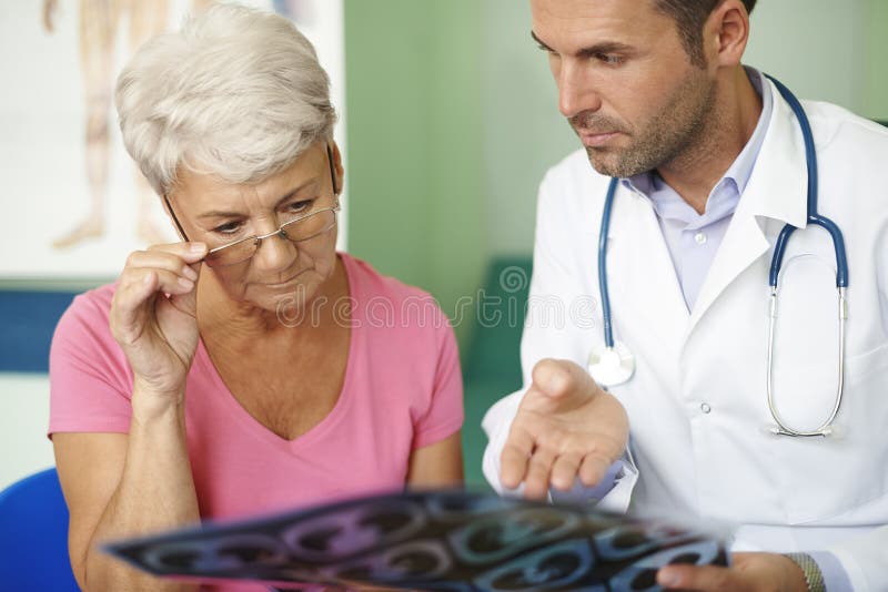 Doctor with his senior patient analyzing medical test. Doctor with his senior patient analyzing medical test