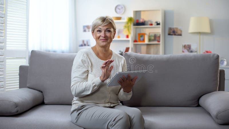 Femme supérieure avec le comprimé souriant à la caméra, achats en ligne, ventes de saison images libres de droits Femme supérieure avec le comprimé souriant à la caméra, achats en ligne, ventes de saison images libres de droits