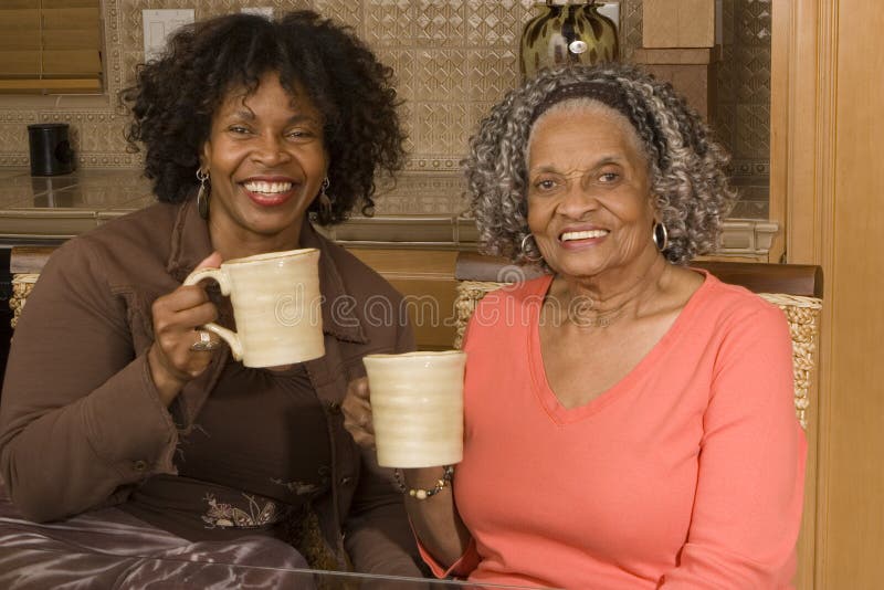 African American mother having coffee with her daughter. African American mother having coffee with her daughter.