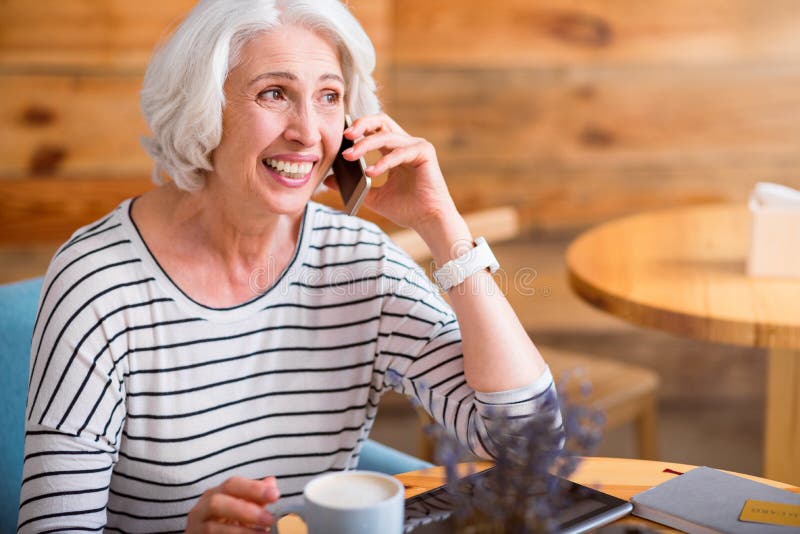 Femme supérieure comblée parlant au téléphone portable photo stock Femme supérieure comblée parlant au téléphone portable photo stock