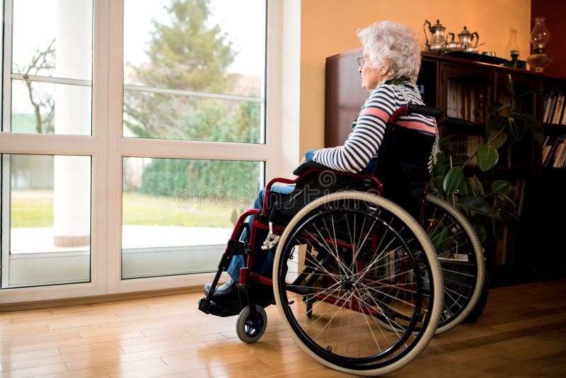 Femme supérieure de solitude s'asseyant dans le fauteuil roulant à la maison de repos