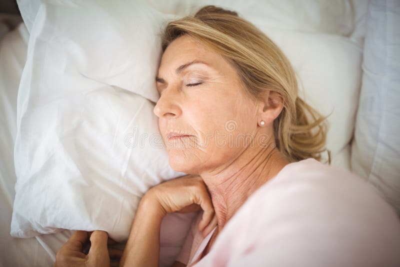 Femme supérieure dormant sur le lit images stock Femme supérieure dormant sur le lit images stock