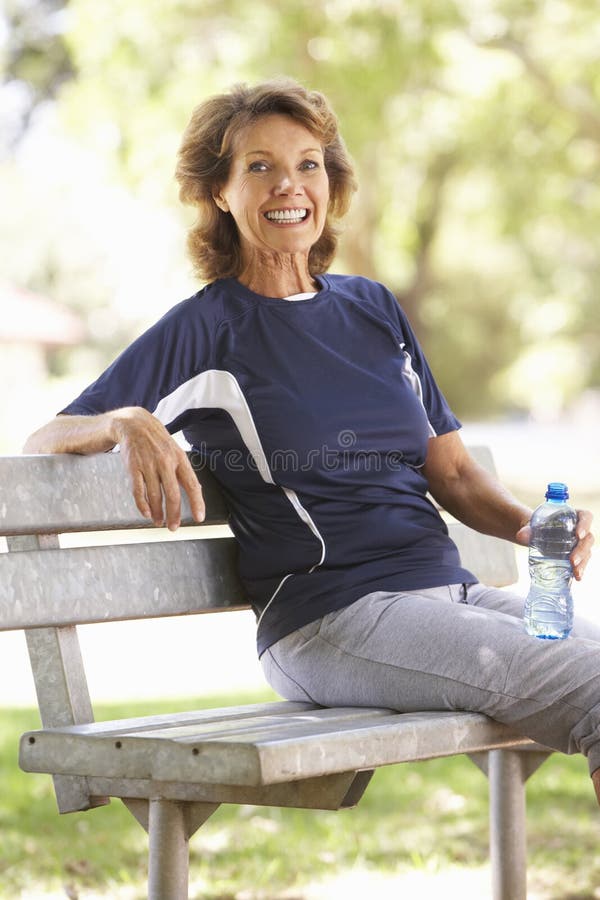 Femme supérieure se reposant après exercice en parc image libre de droits