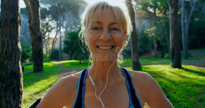 Femme supérieure souriant en parc 4k