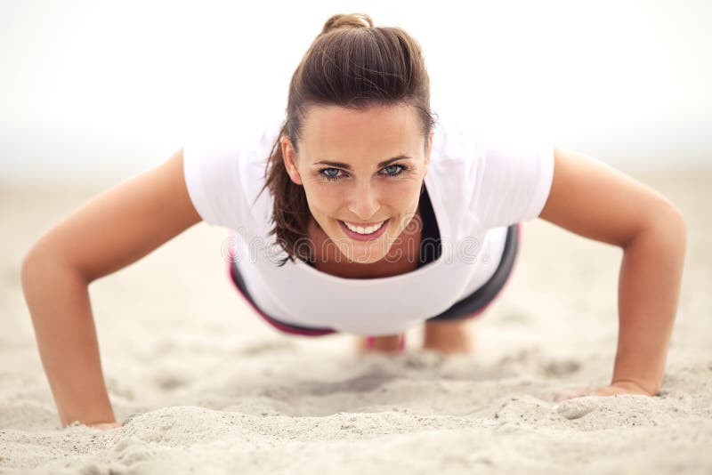 Femme sur la plage souriant tout en faisant soulevez images libres de droits Femme sur la plage souriant tout en faisant soulevez images libres de droits