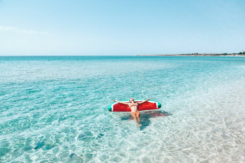 Femme sur le lilo sur la plage photographie stock Femme sur le lilo sur la plage photographie stock