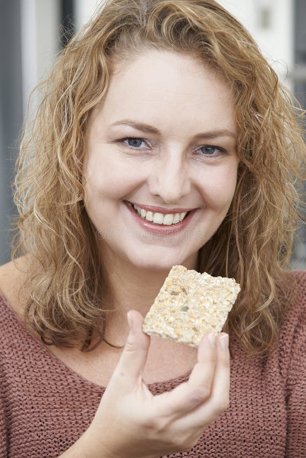 Femme sur le régime mangeant le pain croustillant à la maison image libre de droits Femme sur le régime mangeant le pain croustillant à la maison image libre de droits
