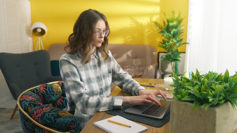Femme taper sur le clavier de l'ordinateur portable à la table. fille travaillant sur un lieu de travail éloigné banque de vidéos