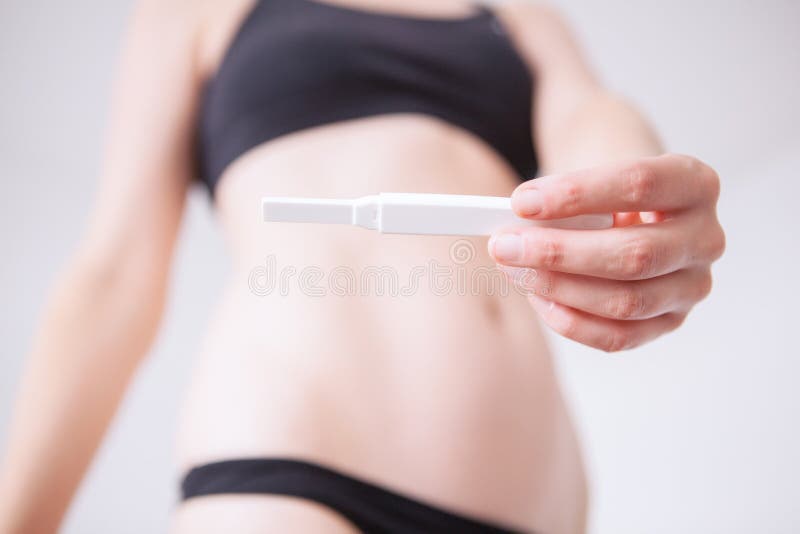 Femme tenant et tenant un essai de grossesse images libres de droits Femme tenant et tenant un essai de grossesse images libres de droits