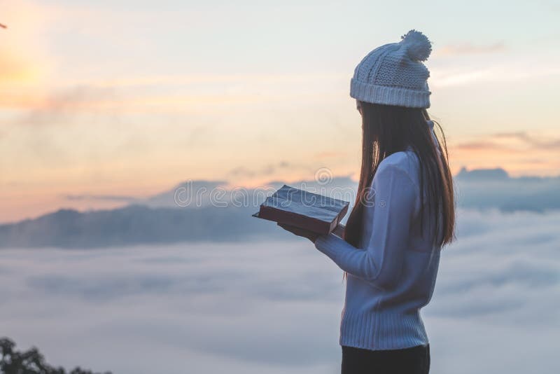 Femme tenant lire la bible sur la montagne dans l'image de matin photo stock Femme tenant lire la bible sur la montagne dans l'image de matin photo stock