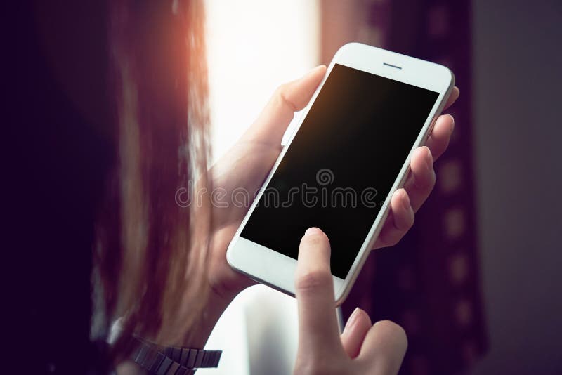 Femme tenant un téléphone blanc avec un écran noir Effet de vintage photographie stock Femme tenant un téléphone blanc avec un écran noir Effet de vintage photographie stock