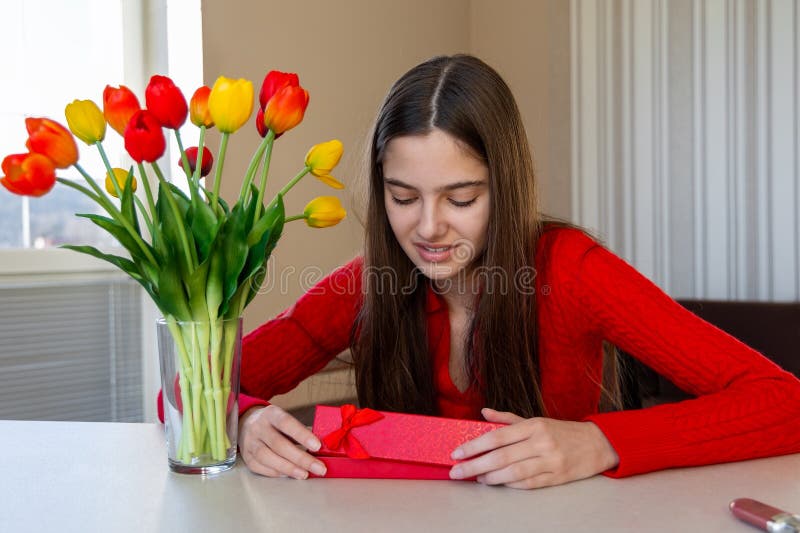 Femme tenant une boîte cadeau près du bouquet de tulipe. photographie stock