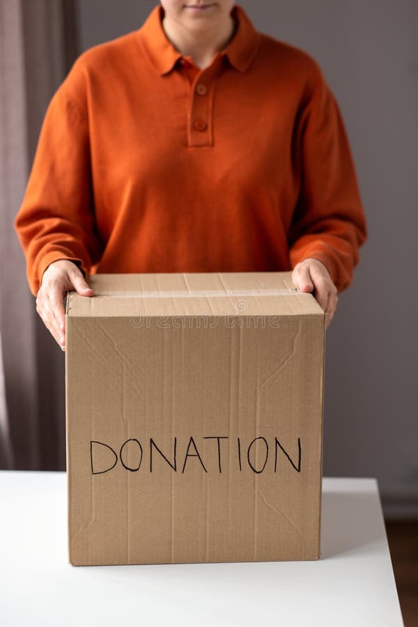Femme tenant une boîte en carton avec dons images stock