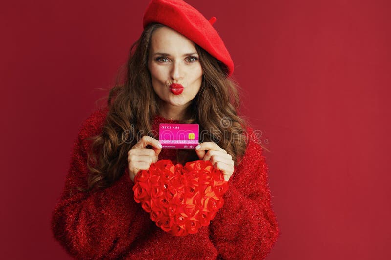 Femme tendance en pull rouge et béret avec coeur rouge image stock