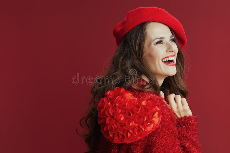 Femme tendance souriante en chandail rouge et béret au coeur rouge images stock
