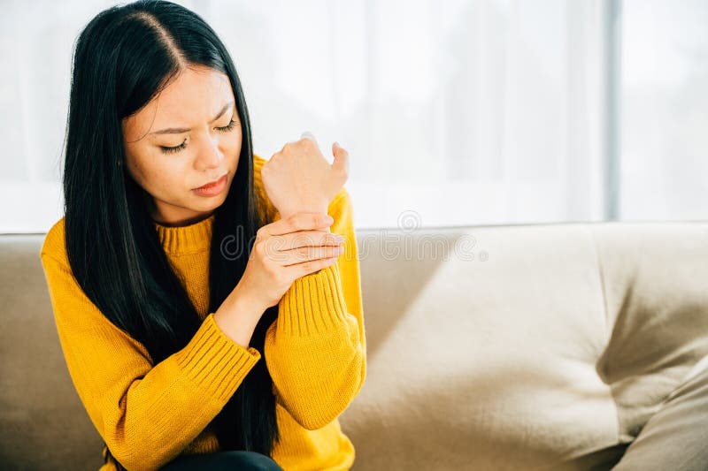 A woman holds her achy wrist indicating Carpal Tunnel Syndrome or wrist pain. Illustrating symptoms inflammation and discomfort in the hand& x27;s anatomy. Health care concept. A woman holds her achy wrist indicating Carpal Tunnel Syndrome or wrist pain. Illustrating symptoms inflammation and discomfort in the hand& x27;s anatomy. Health care concept