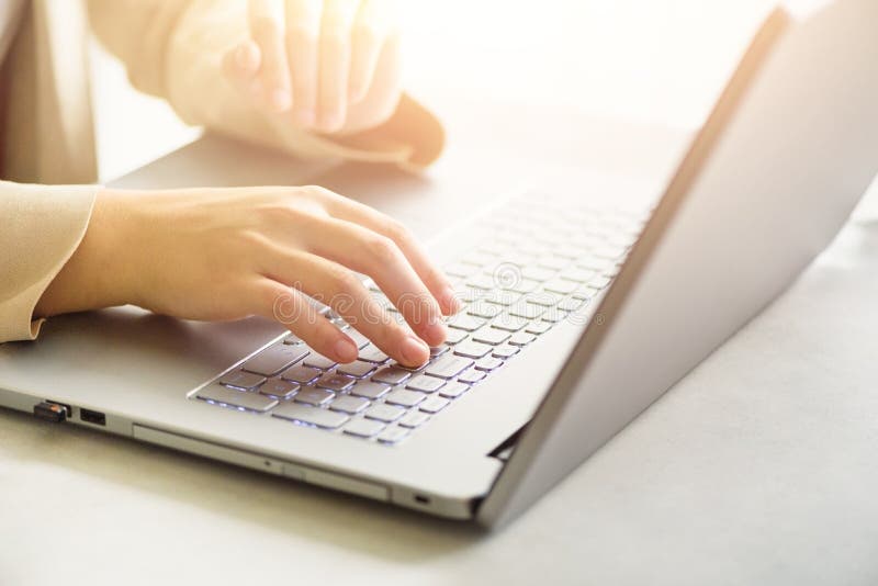Femme travaillant à la fin d'ordinateur La femme remet la dactylographie sur le clavier de l'ordinateur portable, détail en lign image stock