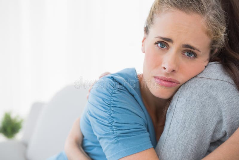 Sad women being consoled by her friend and looking at camera. Sad women being consoled by her friend and looking at camera