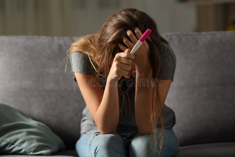 Femme triste se plaignant tenant un essai de grossesse photo libre de droits Femme triste se plaignant tenant un essai de grossesse photo libre de droits