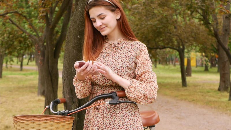 Femme utilise son téléphone pour communiquer avec des amis textos médias sociaux et 4g 5g d'internet. promenade dans le parc banque de vidéos