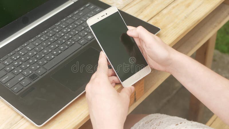 Femme utilise un smartphone. repos extérieur dans la cour de la maison. communiquer avec des amis dans la nature l'internet banque de vidéos